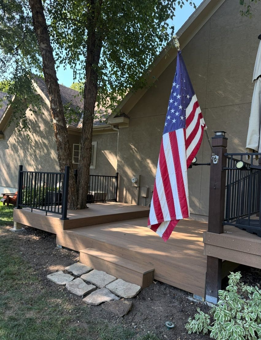 Finished composite deck addition with steps down to the lawn at a Shawnee, KS home